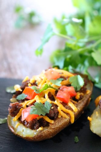 Taco Potato Skins | Crispy paleo potato skins stuffed with taco meat, dairy free cheese, and tomatoes. Served with a dairy free jalapeno cilantro yogurt sauce for dipping. | eatsomethingdelicious.com