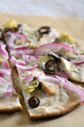 Grilled Pizza | Learn how to cook a pizza on a grill for an extra crispy crust. This gluten and dairy free pizza is topped with alfredo sauce, grilled chicken, and veggies. | eatsomethingdelicious.com
